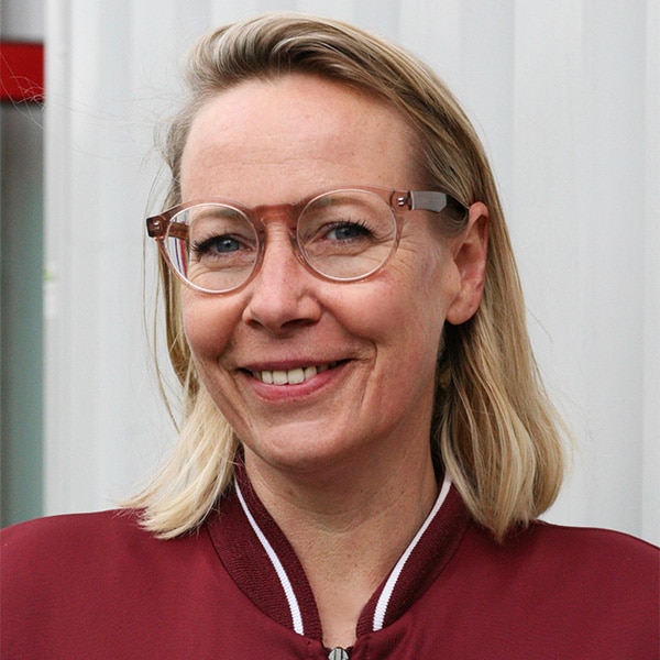 Porträt von Tina Haseler mit Brille und blonden Haaren.