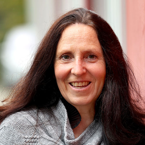 Porträt von Christina Bartels mit langen dunklen Haaren und einem freundlichen Lächeln.