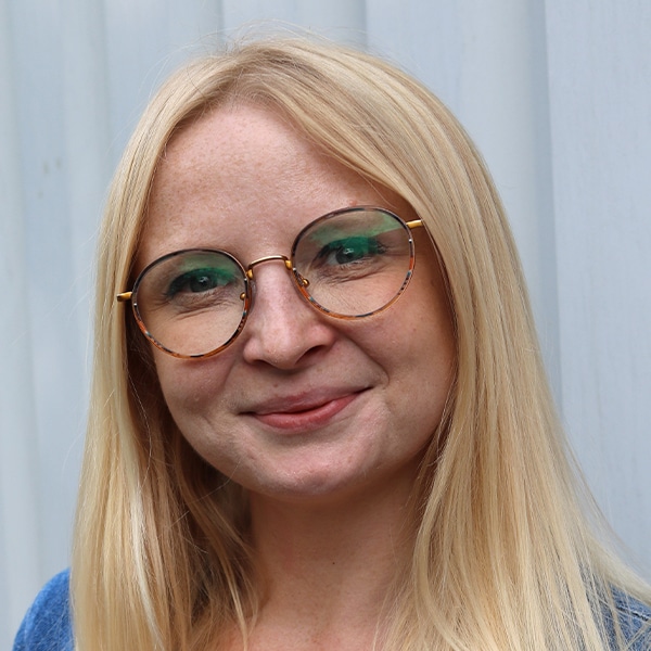 Porträt von Barbara Jastrzabek mit Brille und langen blonden Haaren.