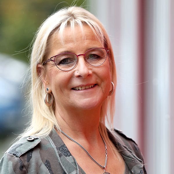 Porträt von Sabine Steinfeldt mit blonden Haaren und Brille.